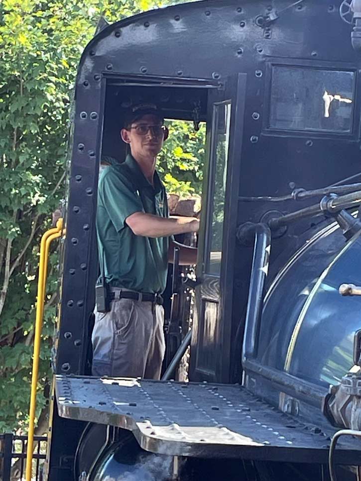 Railroading Counselor and Eagle Scout Matthew Baxter at the throttle of the Climax steam locomotive