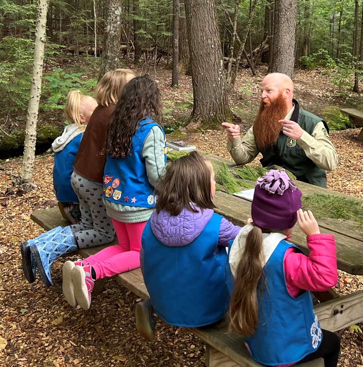 The Forest Ranger is pointing out the differences of the trees.